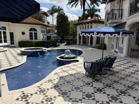 Covered entry with columns, arched doorway, and patterned floor