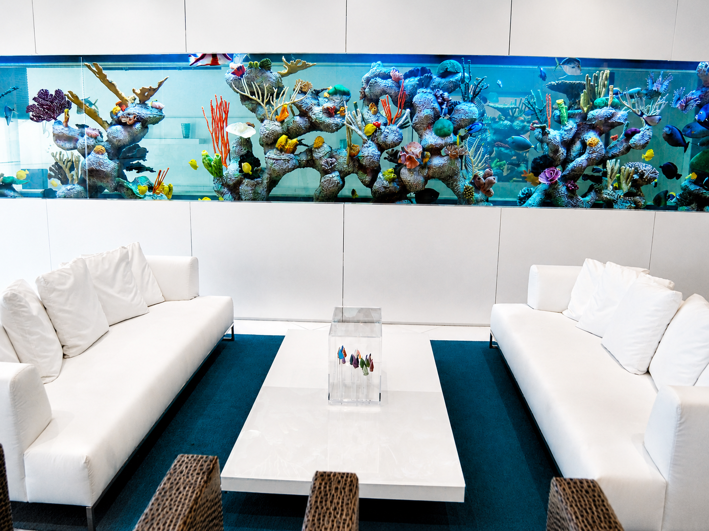 Modern penthouse living space with integrated aquarium wall and minimalist seating