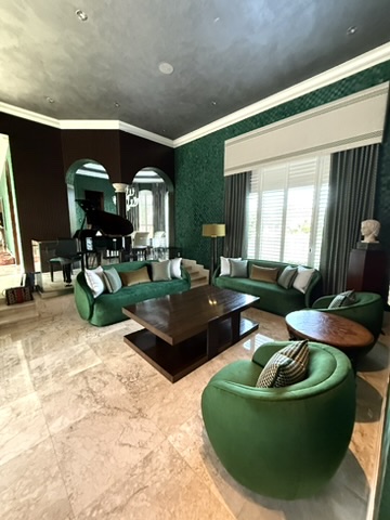 Interior transition hall with deep green wall treatment, framed art, and wood door