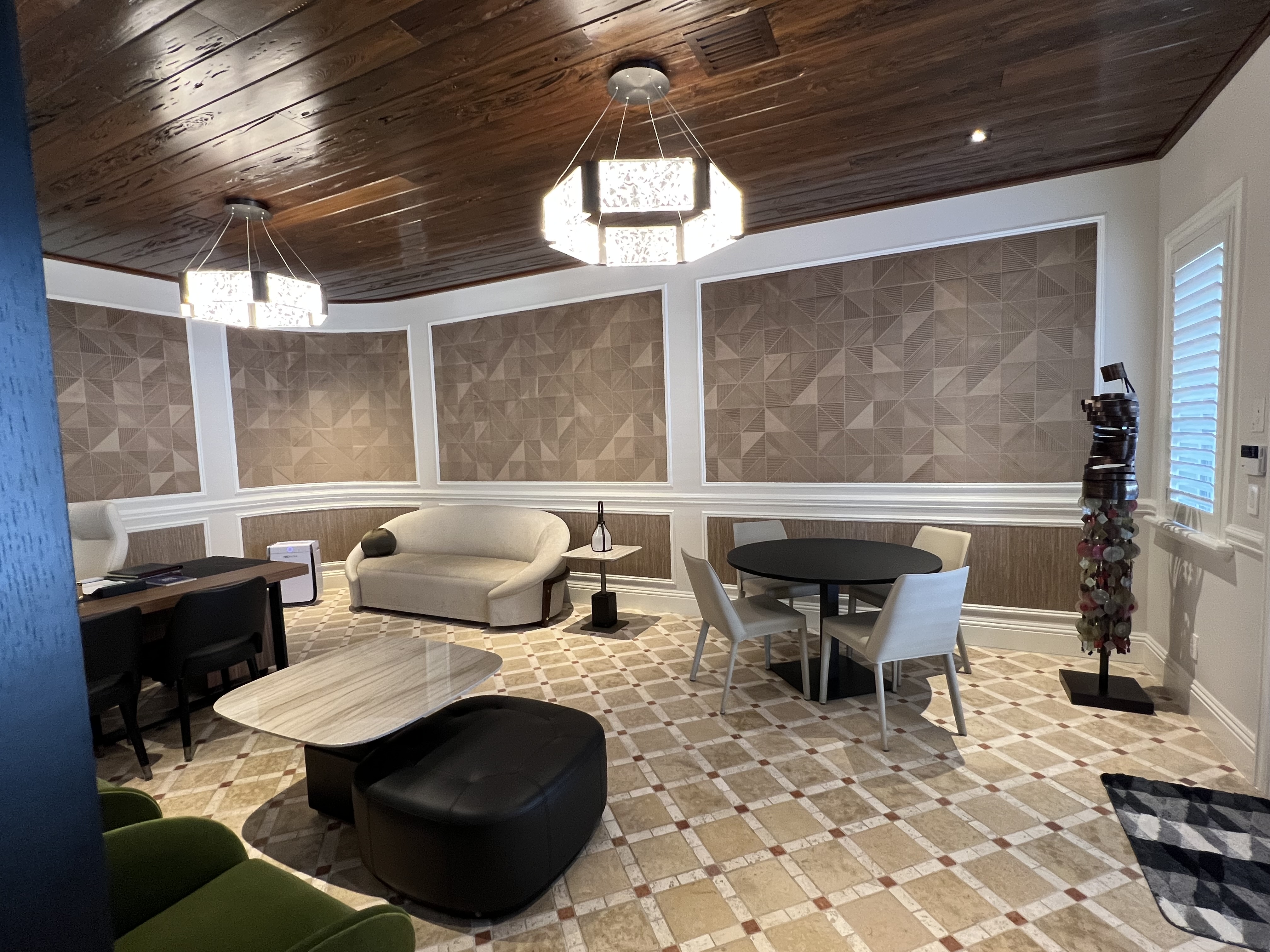 Alternate executive office view with conversation table, curved sofa, and wood ceiling