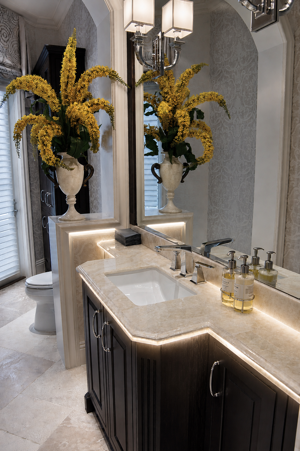 Bathroom vanity with stone top, dark cabinetry, and mirror detail
